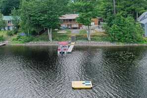 A boat docked at a pier with a house in the background.