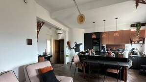 Een moderne woonkamer met een bank, salontafel en eethoek.