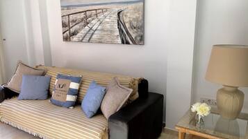 A living room with a striped sofa, a coffee table, and a lamp.