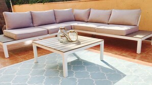 A sectional sofa with cushions, a wooden coffee table, and a patterned rug on a patio. - 2 bed Apt, grt Location, Shared Pool, Outdoor Area (Javea)
