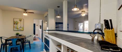 Cocina moderna con encimera, hervidor y bloque de cuchillos.