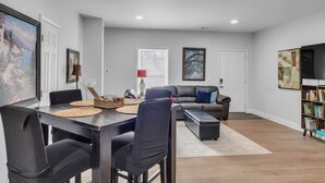 A modern living room with a dining table, sofa, and bookshelf.