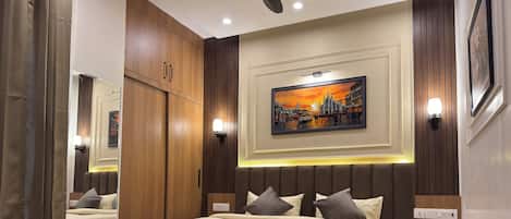 A modern bedroom with a large bed, wooden wardrobe, and a cityscape painting on the wall.
