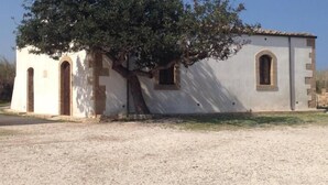 A small, single-story building with a tree in front. - A due Passi Dal Centro (Noto)