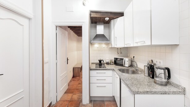 A kitchen with white cabinets, a granite countertop, and a stainless steel sink. - Jungle (Bass 3) (Granada)