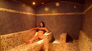 A spa room with patterned walls and a sofa. - ZEcamping 4 étoiles espace aquatique locatif TV 24m2 4 pers (Hyères)