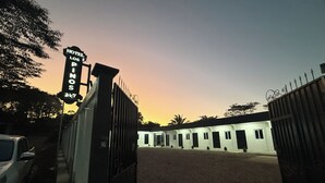 A gated entrance to a hotel with a sign indicating 'HOTEL LOS PINTOS' and a date '24/7'.