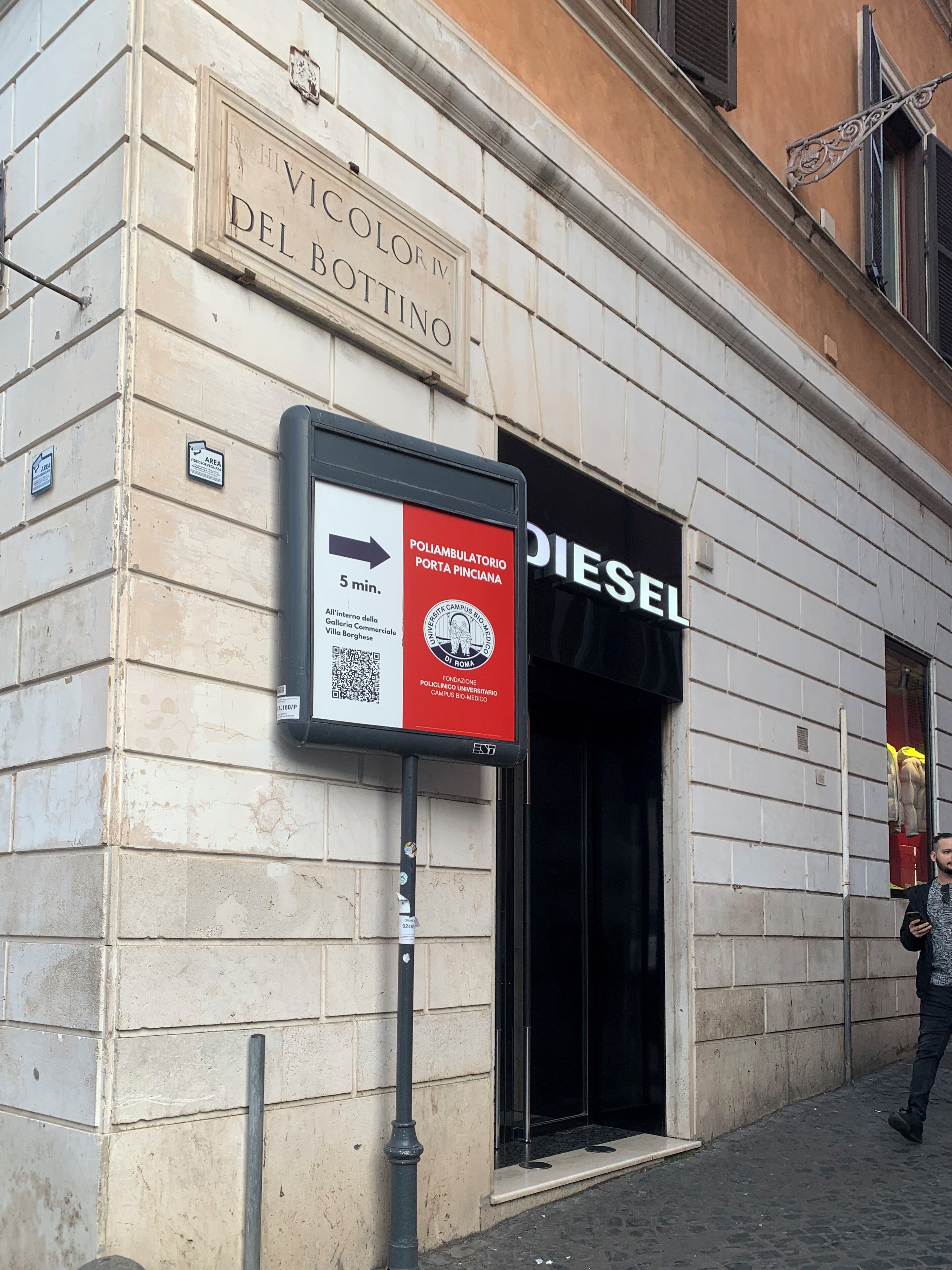 Un edificio con un cartello che indica 'Vicolo Del Bottino' e l'ingresso di un negozio Diesel.