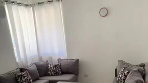 A living room with a grey sofa set, a wooden coffee table, and a grey armchair. - Double Room 300 at the Hotel Legendario (Sosúa)