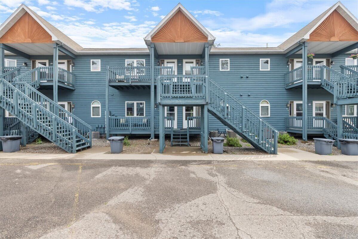 A row of blue buildings with multiple balconies and staircases.