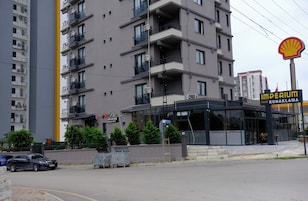A multi-story building with balconies, a Shell gas station sign, and a building labeled 'Imperium Resort Konaklama.'