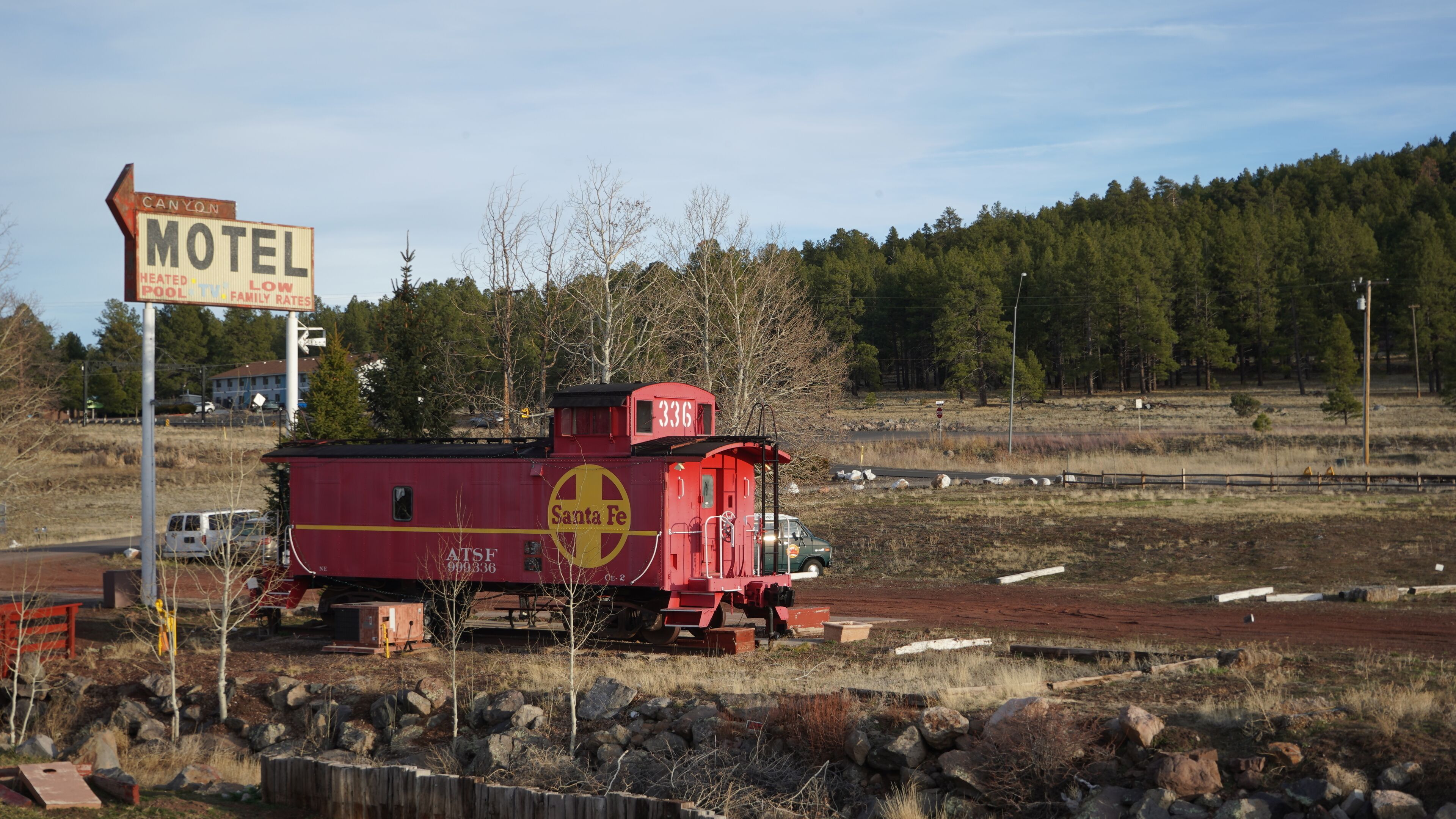 A red caboose with a sign indicating a motel nearby.