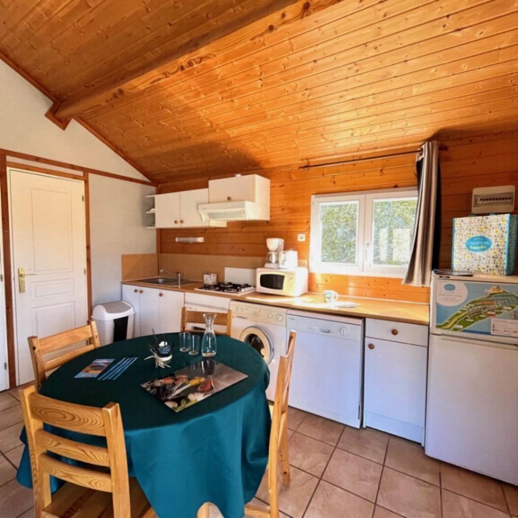 Una cocina acogedora con armarios de madera, un fregadero, un microondas y un refrigerador.
