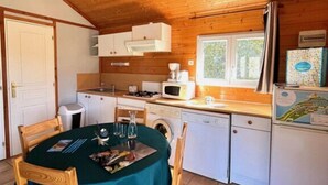 Una cocina acogedora con armarios de madera, un fregadero, un microondas y un refrigerador.