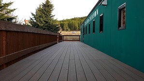 A wooden deck leading to a building with a green exterior and the name "GRAND CANYON" visible. - Railcar on Historic Route 66 (Williams)