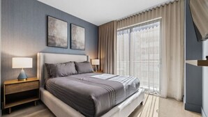 A modern hotel room with a large bed, two bedside tables, a headboard, and a large window with curtains. - Modern Studio with Balcony in Brickell (Miami)