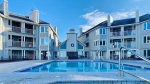 Una piscina rodeada de edificios residenciales de varios pisos con balcones.