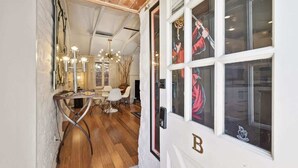 A hallway with a wooden floor, a dining area with chairs and a table, and a door with a number plate. - Exclusive use of the property (All 5 units) (Palm Springs)