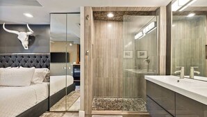 A modern bedroom with a large bed, a glass shower enclosure, and a large mirror. - Exclusive use of the property (All 5 units) (Palm Springs)