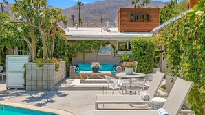 Ein Motel mit Außenbestuhlung, einem Pool und Blick auf die Berge.