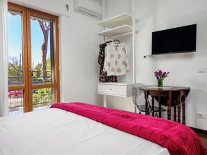 Een slaapkamer met een bed, een bureau en een televisie.