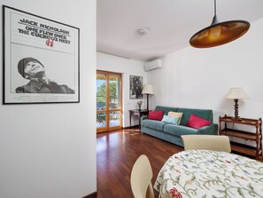 Um quarto com um sofá verde, uma mesa de madeira e um quadro na parede.