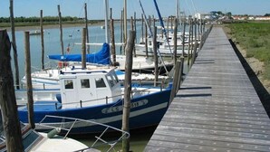 A wooden dock with boats moored alongside. - ZEcamping 4 étoiles familial piscine couverte restaurant et aire de jeux (La Faute-sur-Mer)