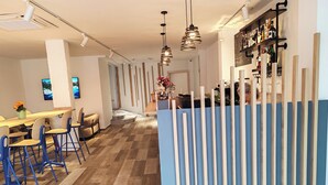 Un intérieur moderne avec un espace bar, un plancher en bois et des cloisons bleues.
