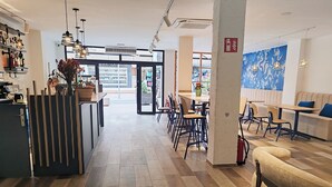 Un intérieur moderne comprenant un comptoir d’accueil, un espace salon et une vue à travers les portes vitrées.