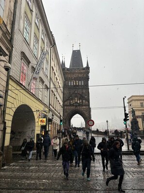 A historic stone bridge with a gothic arch, surrounded by cobblestone streets and old buildings. - Spacious 4BR Apartment by Charles Bridge (Praha 1)