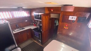 Cocina compacta con microondas, estufa, lavaplatos y un pequeño comedor.