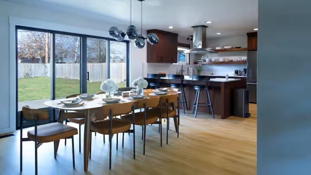 A modern kitchen with a dining area, large windows, and a view of the backyard. - Stylish Mid-Century Modern Home - Near DT Portland for your perfect getaway! (Milwaukie)