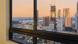 A cityscape with high-rise buildings, including a construction site, viewed through a window. - Downtown Miami Apt: Pool, Skyline Views, Gym Access (Miami)