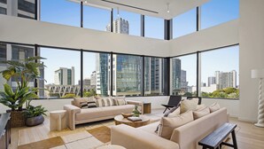 A spacious living room with large windows, a sofa set, a coffee table, and a bench. - Downtown Miami Apt: Pool, Skyline Views, Gym Access (Miami)