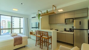 Un appartement moderne doté d’une kitchenette, d’un coin repas et d’un lit.