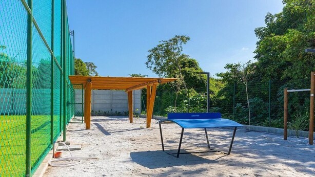 A badminton court with a wooden pavilion and a blue table tennis table. - Makia Beach #c22 - Apto Inteligente by Carpediem (Ipojuca)