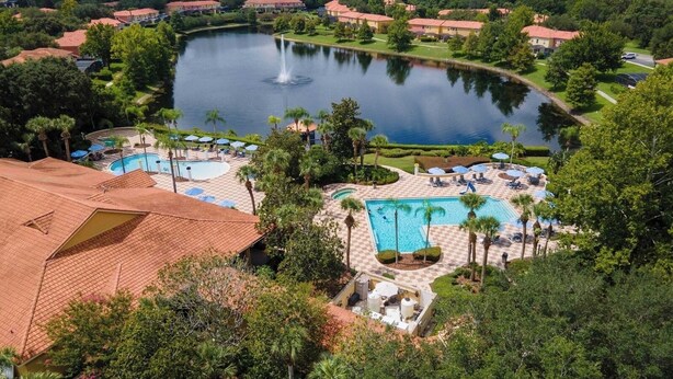 Ein Resort mit einem großen zentralen Pool, einem kleineren Pool und einem See mit einer Springbrunnen.