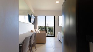 Une chambre d’hôtel moderne dotée d’un coin repas, d’un canapé et d’un balcon avec vue.