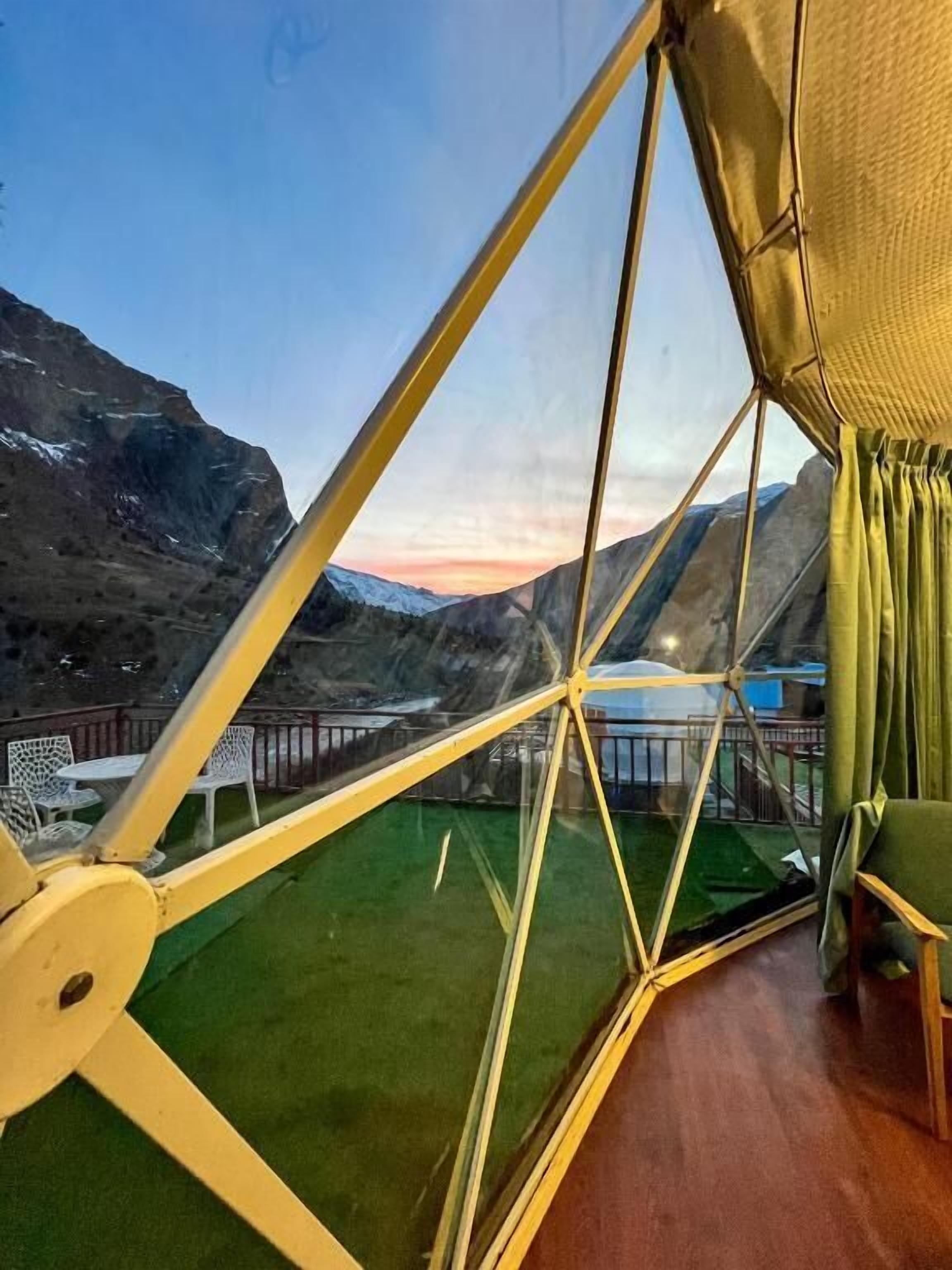 Una estructura de cúpula geodésica con vistas a un paisaje montañoso.