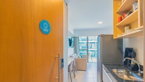 A modern kitchen with a granite countertop, a built-in sink, and a wooden shelf above it. - Makia Beach #d205 - Flat in Ipojuca by Carpediem (Ipojuca)
