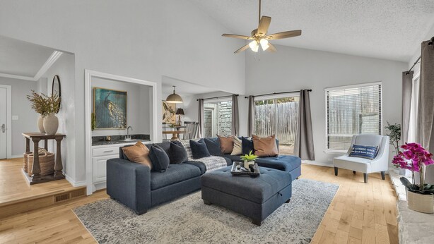A modern living room with a sectional sofa, a ceiling fan, and a dining area in the background. - Spacious Hilltop Retreat in Upscale Cul-de-Sac Neighborhood (Tulsa)