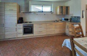 Una cocina con estufa, horno, microondas y armarios de madera.