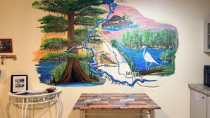 A wall mural with a map-like design, a table, and a framed welcome sign.
