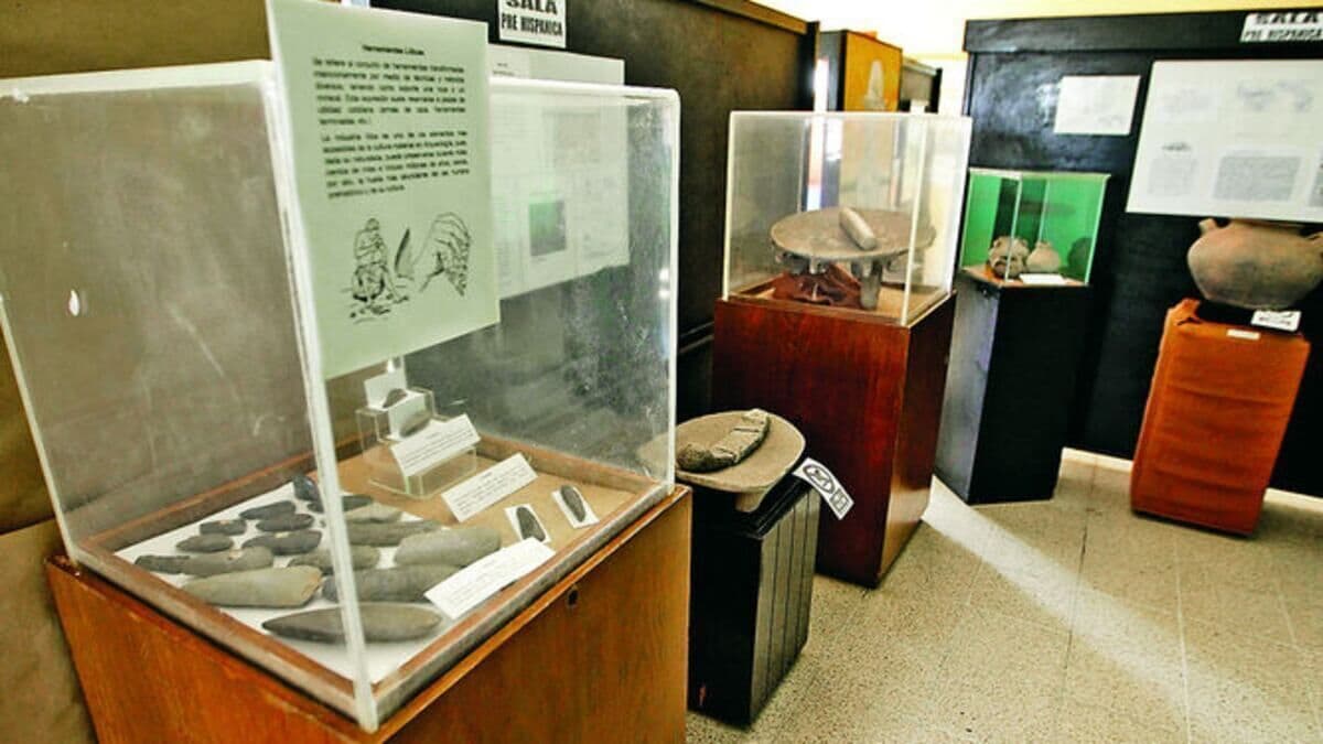 Eine Vitrine mit Artefakten, ein Holzkabinett und Informationsschilder.