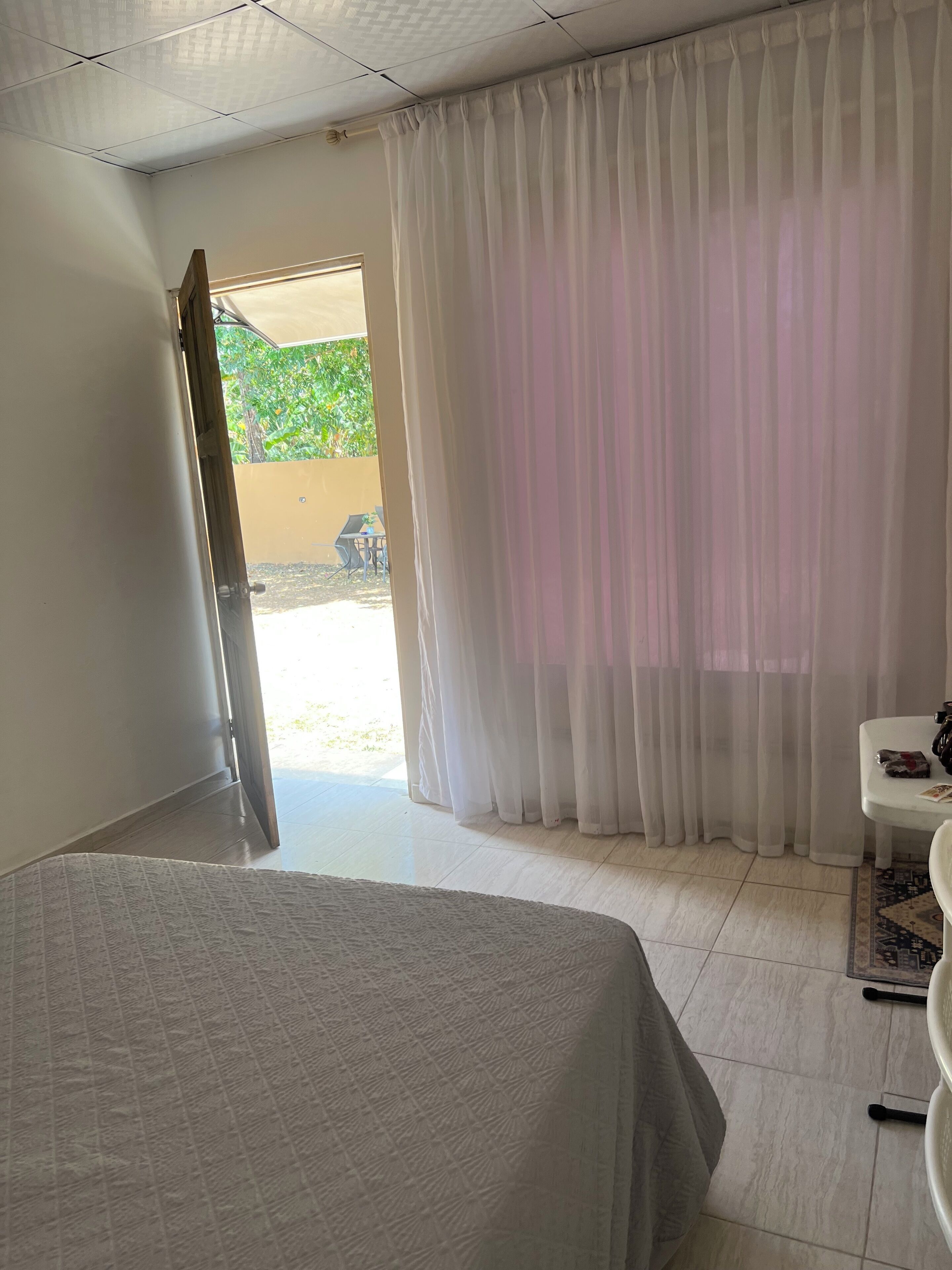 Habitación de hotel con cama, escritorio, silla y vistas al exterior.
