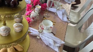 A table set with a variety of food items, including pastries, fruits, and nuts, arranged on a table with a decorative centerpiece. - olivias village room (Capellania)