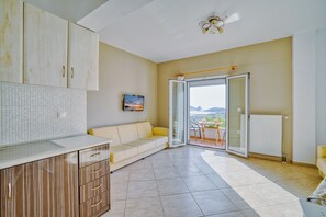 Apartamento família, sacada, vista para o mar | Área de estar | TV de tela plana 32 polegadas com canais a cabo