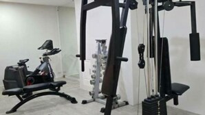 A gym with various exercise equipment including a bench press, a squat rack, and a cable machine. - Smile Court Pattaya (Pattaya)