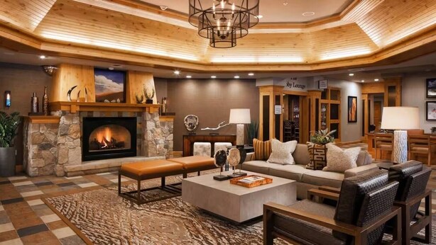 A spacious lobby with a stone fireplace, a large sofa, and a bar area.