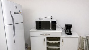 A kitchenette with a white refrigerator, a microwave, and a coffee maker on a white cabinet. - Apartment just minutes from Copacabana Beach. (Rio de Janeiro)